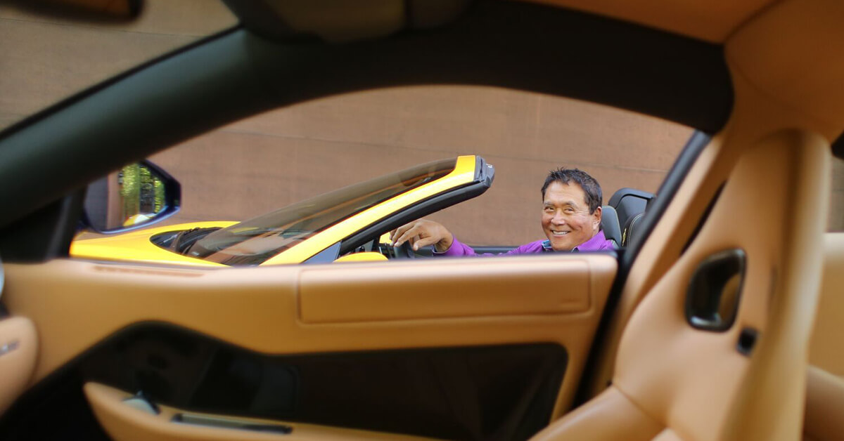 Robert Kiyosaki in his yellow Ferrari