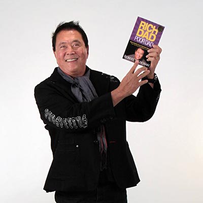 Robert Kiyosaki holding his New York Times best-selling book, Rich Dad Poor Dad